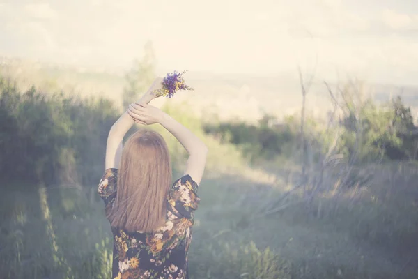 Vrouw hand bloemen in veld — Stockfoto