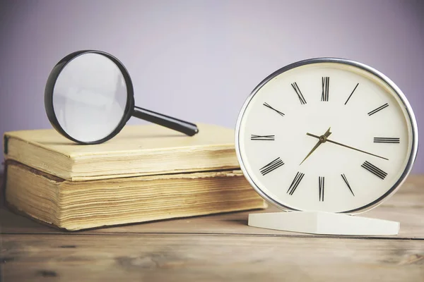 clock, magnifying glass and book