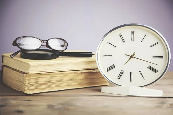 clock, magnifying glass and book