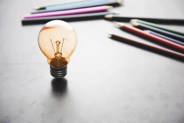 Glödlampa och pennor — Stockfoto