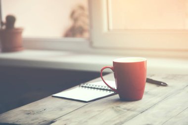 Kupası, not defteri ve kalem masada