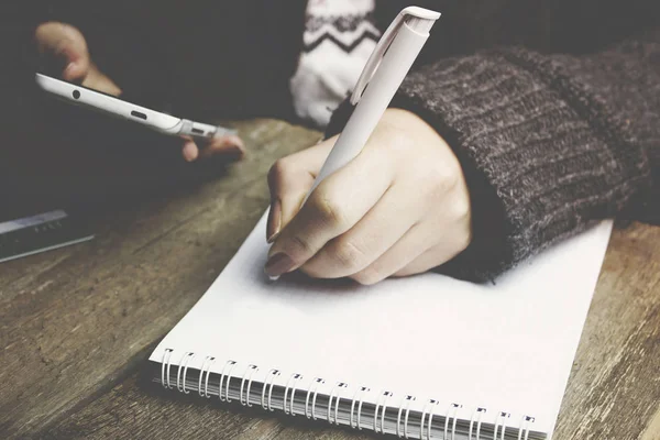 Woman hands with pen writing on notebook Stock Picture