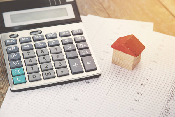 калькулятор и дом на бумаге
