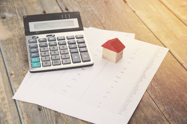 калькулятор и дом на бумаге
