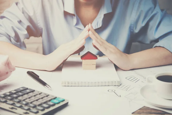 Mains de femme protégeant une maison — Photo