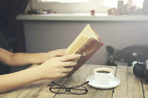 Mulher sentada à mesa de madeira e livro de leitura — Fotografia de Stock