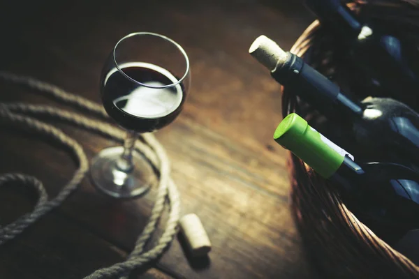 Copo de vinho e garrafas na cesta — Fotografia de Stock