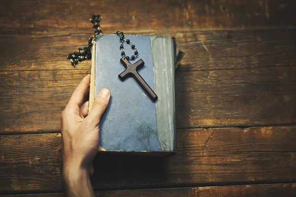 Ręką człowieka krzyż i Biblia — Zdjęcie stockowe