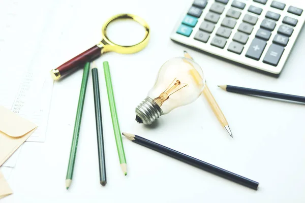 Ampoule, cahier et calculatrice — Photo