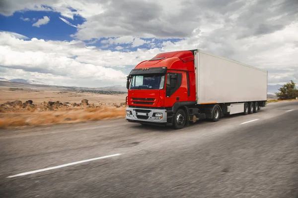 Bulanık asfalt yolda kırmızı kamyon 