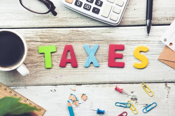 Taxes text on wooden table — Stock Photo, Image