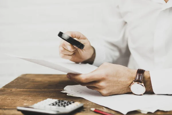 Businessman looking through a magnifying glass — Stock Photo, Image