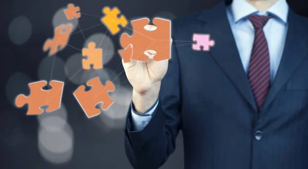 stock image Businessman touching  puzzle pieces, close up 