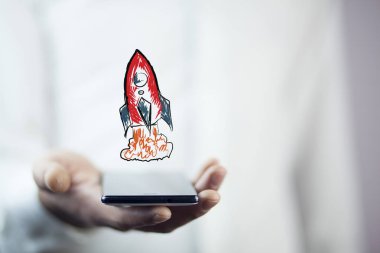 Kırmızı roket simgesi olan telefon tutarak işadamı 