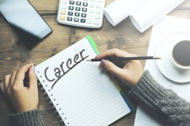kariyer kelime defter üzerinde yazılı. kadın eli kalem ile