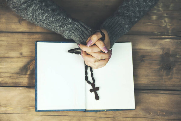 young Woman praying with  bible  on table