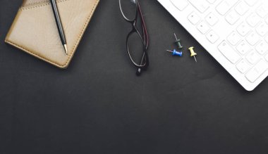 klavye, defter, kalem ve siyah arka plan üzerine gözlük