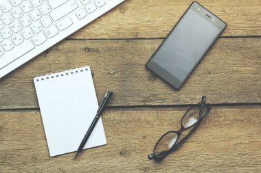 klavye, notebook, telefon ve gözlük masada