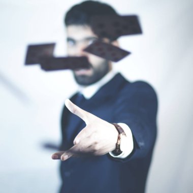 Adam havaya iskambil kağıtları atıyor.