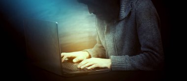 haker elleri dizüstü bilgisayarın klavyesinde yazıyor.