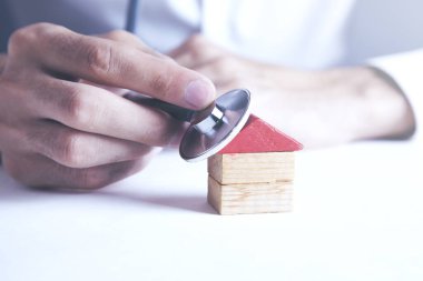 House diagnostics Model house with hand and stethoscope