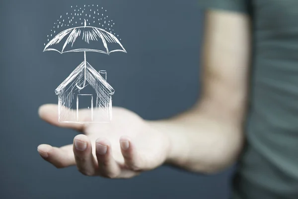 Businessman drawing umbrella over house