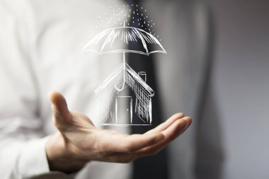 Businessman drawing umbrella over house