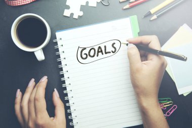 Businessperson's Hand Writing Goal Concept On Notebook