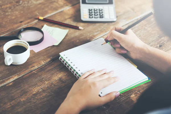 Woman hand notepad and calculator on table — Stok fotoğraf