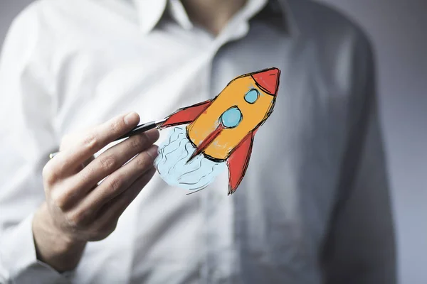 Üzletember kézi toll és rakéta — Stock Fotó