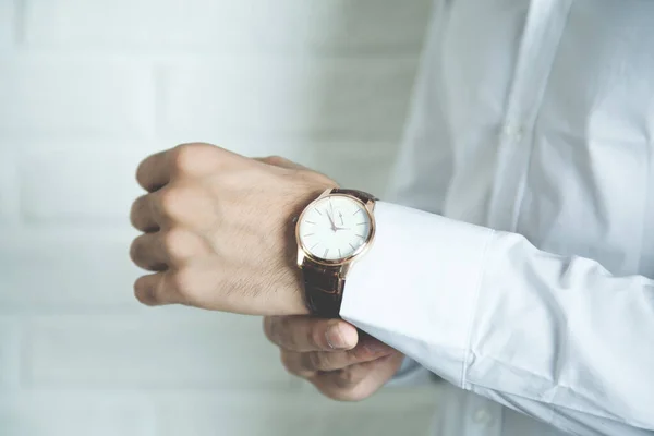 Hombre de negocios comprobando el tiempo en su reloj de pulsera —  Fotos de Stock