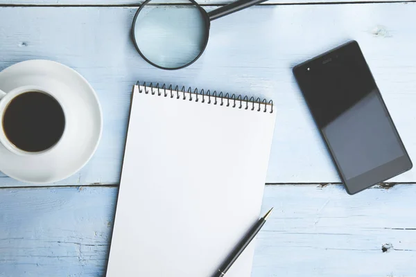 Coffee cup, smartphone and blank notepad on wooden table backgro — 스톡 사진