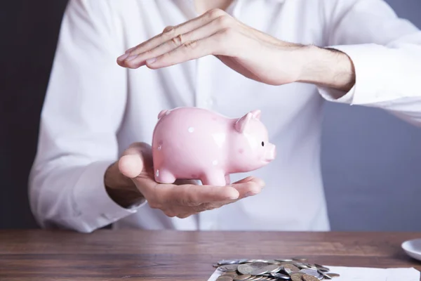 Hombre moneda de mano y alcancía — Foto de Stock