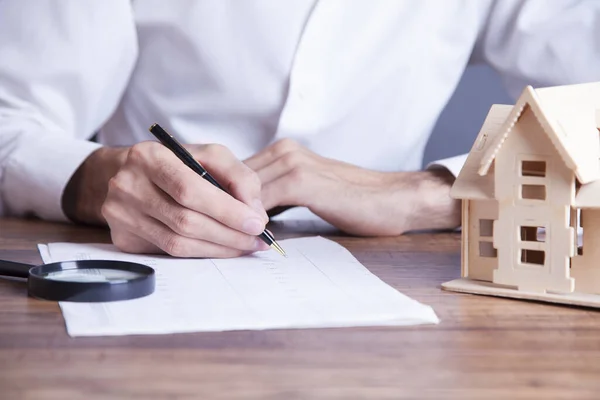 Homem de negócios mão documento e modelo de casa — Fotografia de Stock