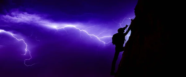 Mann besteigt während des Blitzes einen Berg — Stockfoto