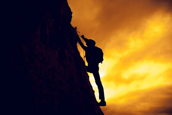 Άνθρωπος των επιχειρήσεων σκαρφαλώνει το βουνό μέσα σε βοήθεια του σχοινιού — Φωτογραφία Αρχείου