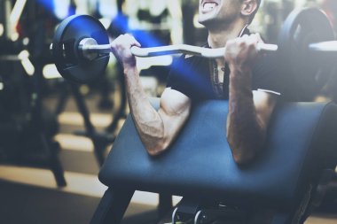 Spor salonunda büyük halter alıştırmalar yapan kaslı vücut geliştirmeci adam