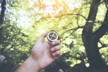 Genç adam, el pusulası ağaç zemininde