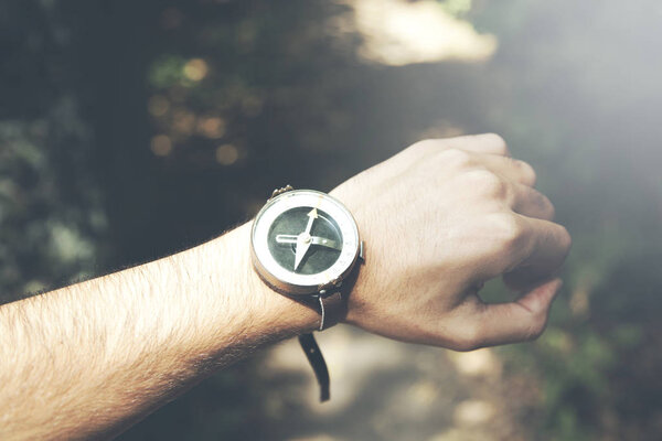 Рука, держащая компас в природе
