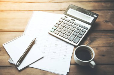 Finans gazetesinde kahve fincanı olan hesap makinesi.