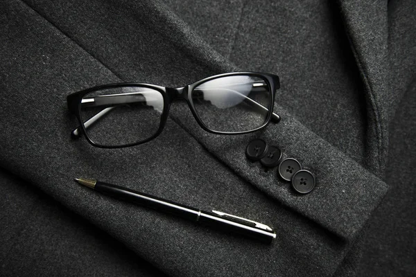 眼镜和钢笔在外套底座上 — 图库照片