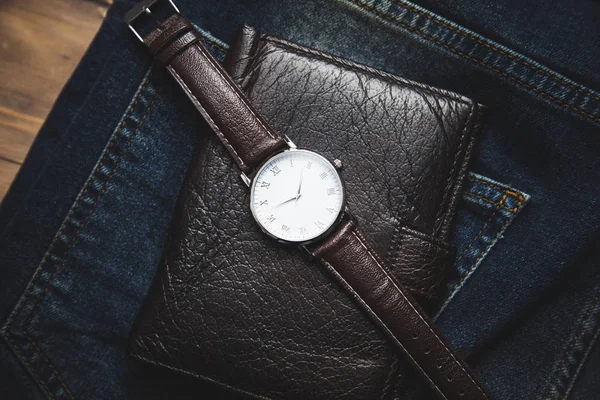 ジーンズを背景にした男の腕時計と財布 — ストック写真