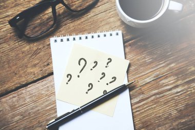 Bir fincan kahveyle kağıtta soru işaretleri