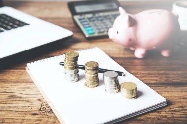 Bozuk paralar ve masada bilgisayar olan kumbaralar.