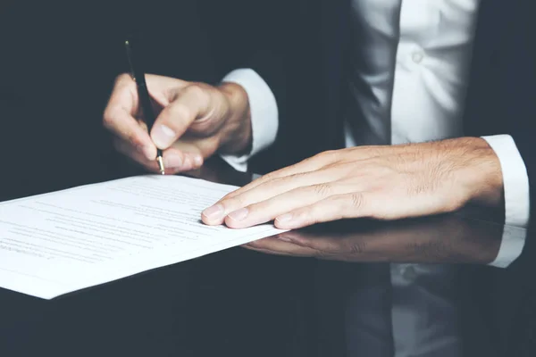 Businessman writing correspondence or signing a document using a fountain pen