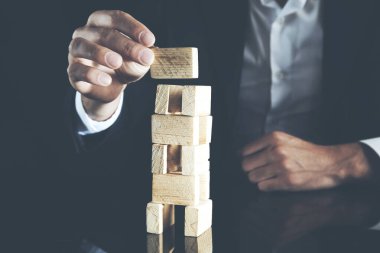 İşadamı bir piramit boş tahta küpleri ile yapma