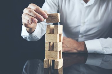 İşadamı bir piramit boş tahta küpleri ile yapma