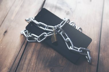 Zincirli akıllı telefon ahşap masa arkasında