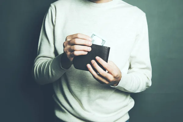 Closeup on a man getting money out of his wallet