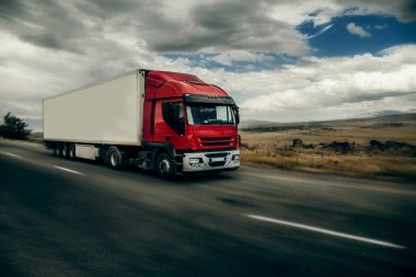 yol ve hareketli kırmızı kamyon ile kırsal manzara